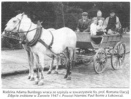 Stare czarno-białe zdjęcie: biały koń zaprzężony do drewnianego wozu na brukowanej ulicy; na wozie siedzi kilka osób.